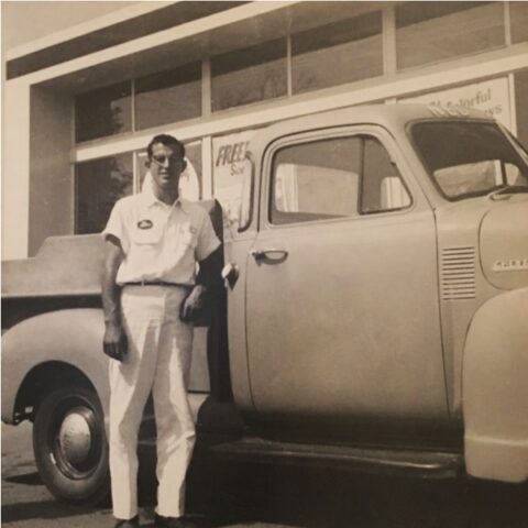 Phoenix Car Rental founder standing beside one of the original rental trucks, circa 1971